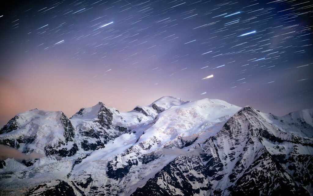 The night sky over a mountain range with stars in the sky